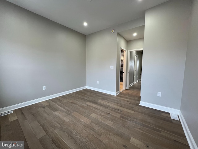 spare room featuring dark wood-style floors, visible vents, baseboards, and recessed lighting