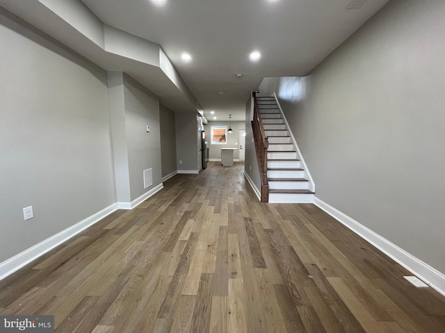 basement with recessed lighting, visible vents, wood finished floors, baseboards, and stairs