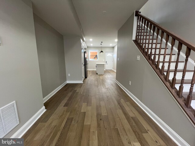 hallway featuring baseboards, visible vents, dark wood-style flooring, stairs, and recessed lighting