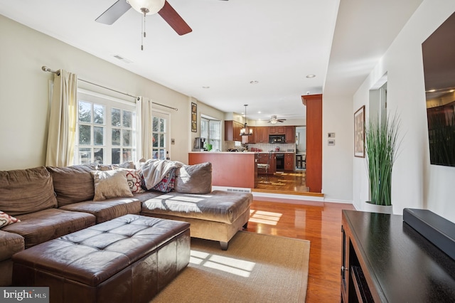 living area with light wood-type flooring, visible vents, recessed lighting, baseboards, and ceiling fan