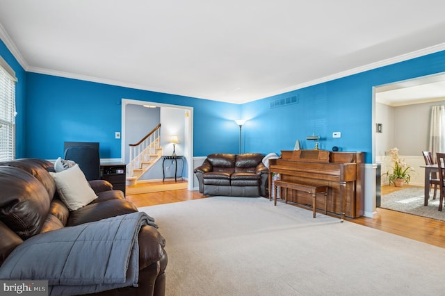 living room with crown molding, stairway, visible vents, and a wealth of natural light