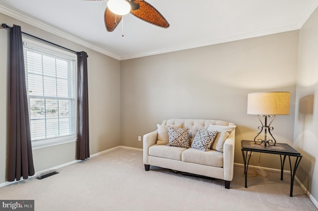 sitting room featuring a ceiling fan, visible vents, carpet floors, baseboards, and crown molding