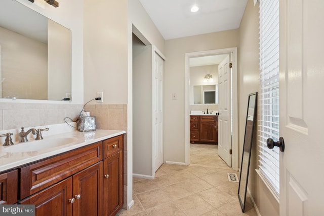 bathroom featuring tile patterned floors, two vanities, visible vents, and a sink