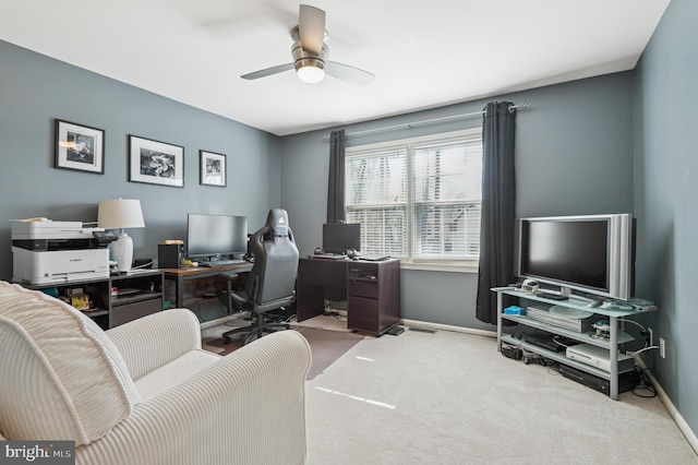 carpeted office featuring baseboards and a ceiling fan