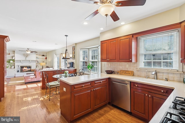 kitchen featuring ceiling fan, light countertops, appliances with stainless steel finishes, a peninsula, and a sink