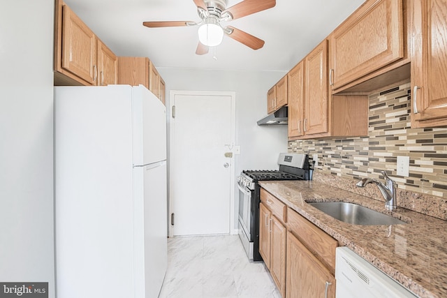 kitchen featuring marble finish floor, a sink, under cabinet range hood, backsplash, and white appliances