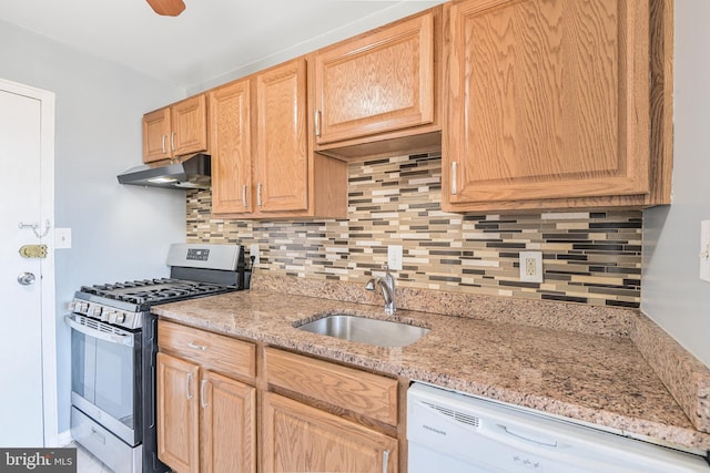 kitchen with backsplash, under cabinet range hood, white dishwasher, gas stove, and a sink