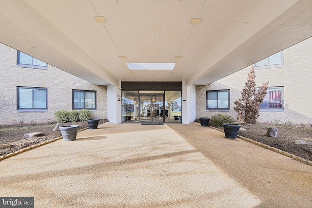 property entrance with a patio and brick siding