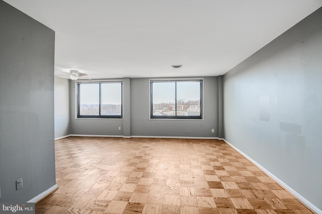 unfurnished room featuring visible vents, baseboards, and ceiling fan