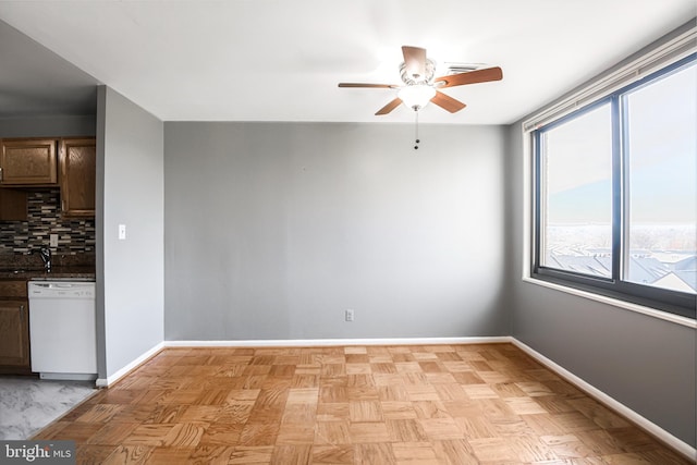 spare room featuring a ceiling fan and baseboards