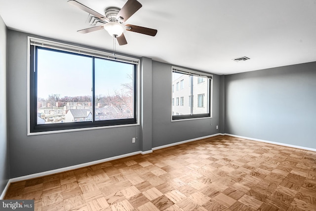 unfurnished room with visible vents, baseboards, and ceiling fan