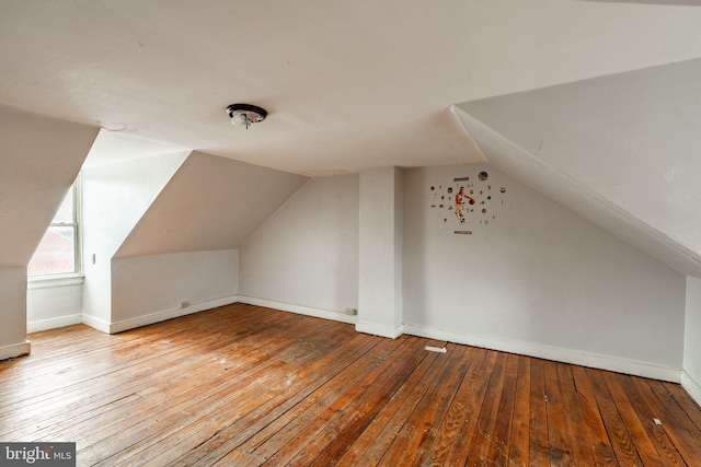 additional living space featuring vaulted ceiling, baseboards, and hardwood / wood-style flooring