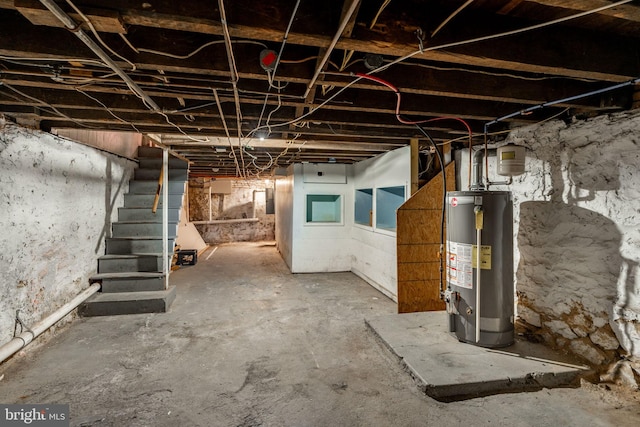 unfinished basement with stairway and gas water heater