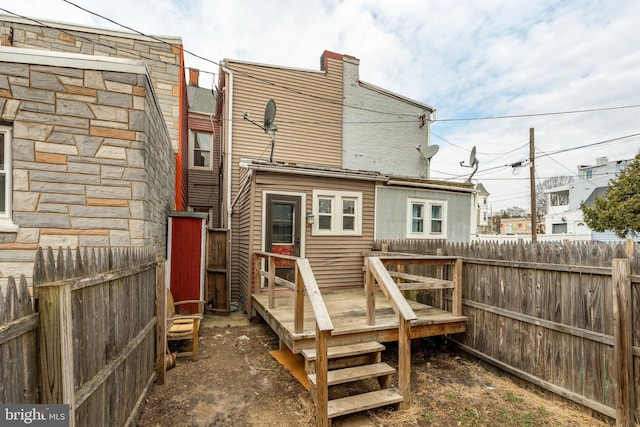 rear view of house with fence private yard and a wooden deck