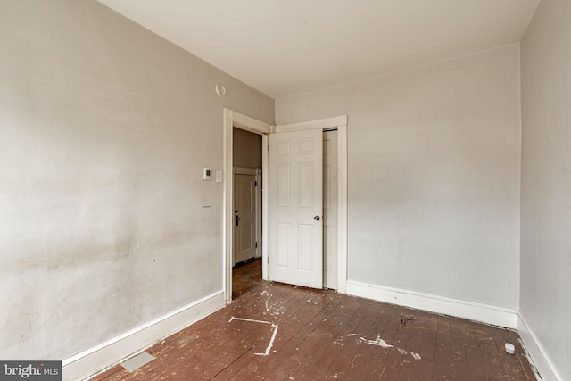 spare room with hardwood / wood-style flooring and baseboards