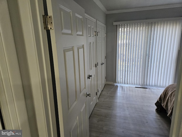 doorway to outside featuring visible vents, wood finished floors, and crown molding