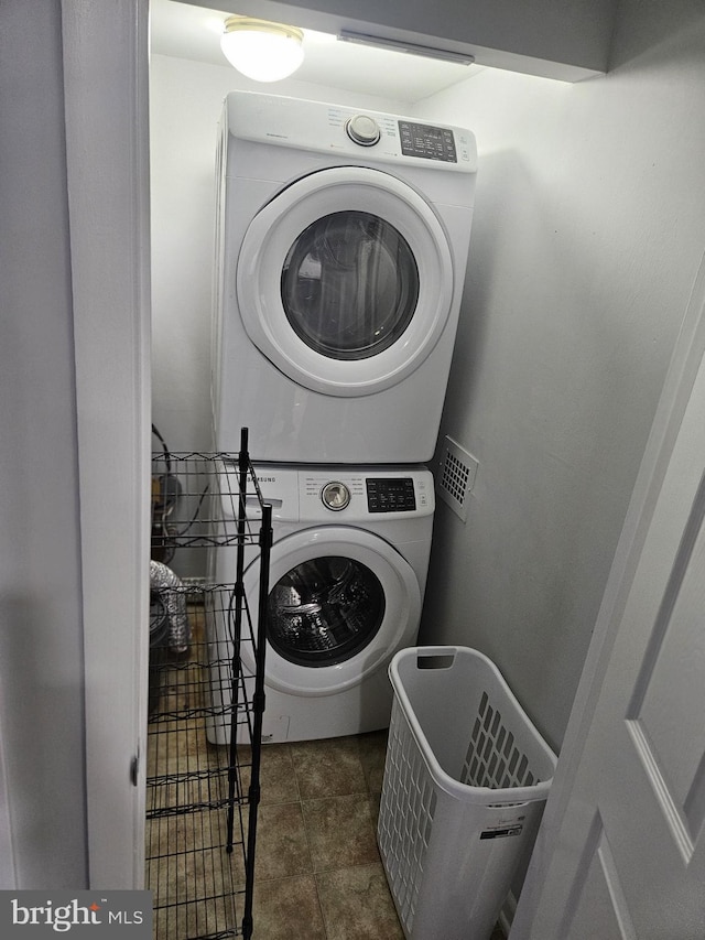 washroom with laundry area, visible vents, and stacked washer / drying machine