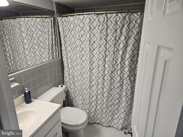 full bath with a shower with shower curtain, vanity, toilet, and tile walls