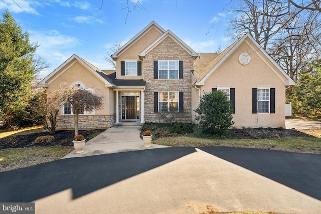 view of front facade featuring stone siding and stucco siding