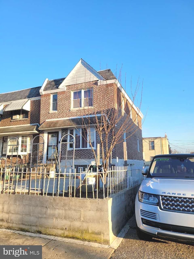 view of front of home featuring a fenced front yard and brick siding