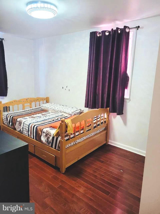 bedroom with wood finished floors and baseboards