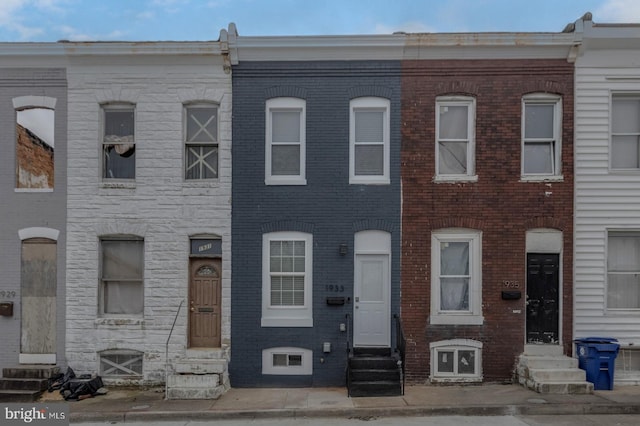 view of property featuring entry steps and brick siding