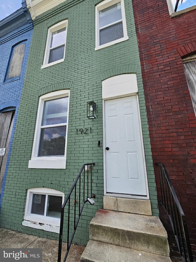 view of exterior entry featuring brick siding