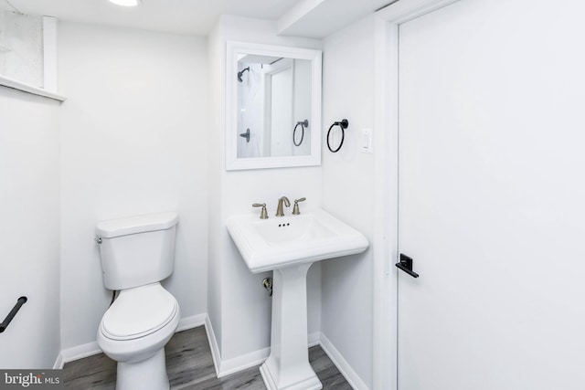 bathroom featuring toilet, baseboards, and wood finished floors