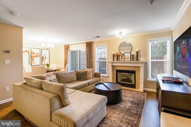 living area featuring a fireplace with flush hearth, an inviting chandelier, wood finished floors, and ornamental molding