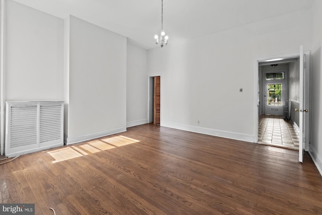 interior space with visible vents, a notable chandelier, baseboards, and wood finished floors