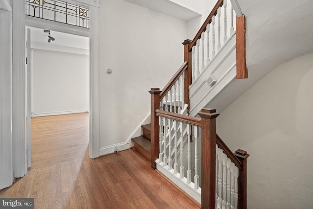 staircase with wood finished floors and baseboards