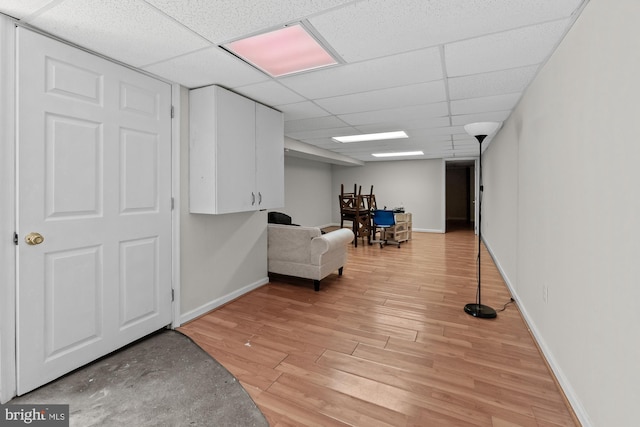 unfurnished room featuring a paneled ceiling, light wood-style floors, and baseboards