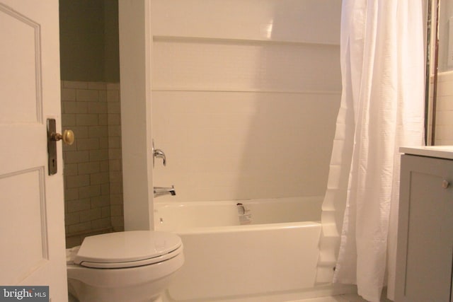 bathroom featuring toilet, shower / bath combo, and tile walls