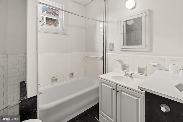 full bathroom featuring a wainscoted wall, tile walls, shower / bathtub combination, visible vents, and vanity