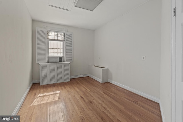 empty room with wood-type flooring and baseboards