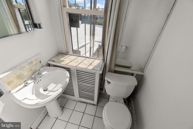 bathroom featuring plenty of natural light, toilet, and tile patterned floors