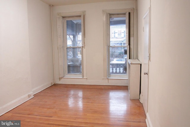 unfurnished room featuring light wood-type flooring and baseboards