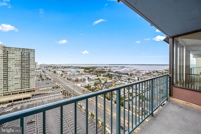 balcony featuring a water view and a city view