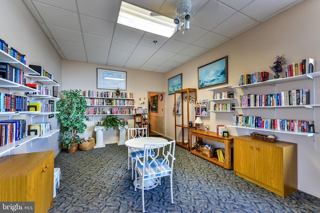 office area with ceiling fan, a drop ceiling, and carpet flooring