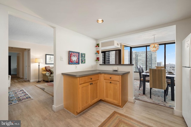 kitchen featuring a notable chandelier, baseboards, open shelves, light wood finished floors, and dark countertops