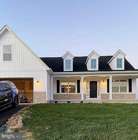 view of front of property featuring aphalt driveway, brick siding, and a front lawn