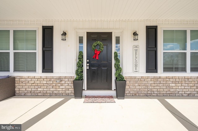 entrance to property with brick siding and covered porch