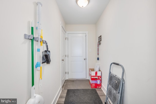 doorway to outside featuring wood finished floors and baseboards