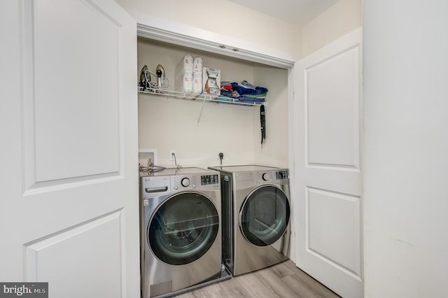 laundry area featuring light wood-style flooring, laundry area, and washer and clothes dryer