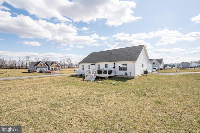 back of property featuring central air condition unit, a lawn, and a wooden deck