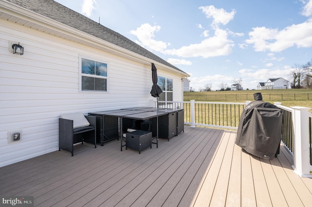 wooden terrace with a yard, outdoor dining space, and fence