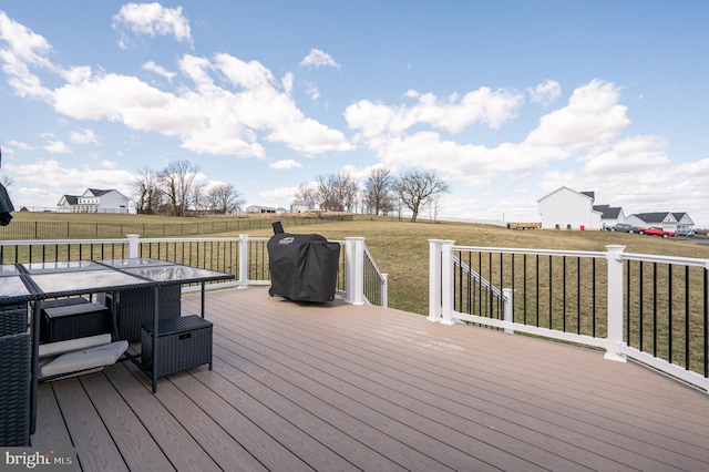 wooden deck with a yard, a rural view, a grill, and fence