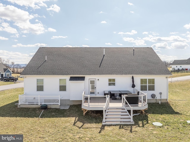 back of property with a lawn, a wooden deck, and a shingled roof