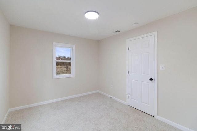 carpeted empty room with visible vents and baseboards