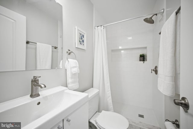 full bathroom with tiled shower, toilet, and vanity